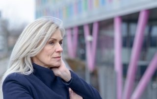 An woman with gray long hair looking pensive