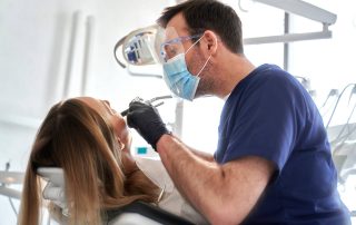 A dentist examining a woman's mouth