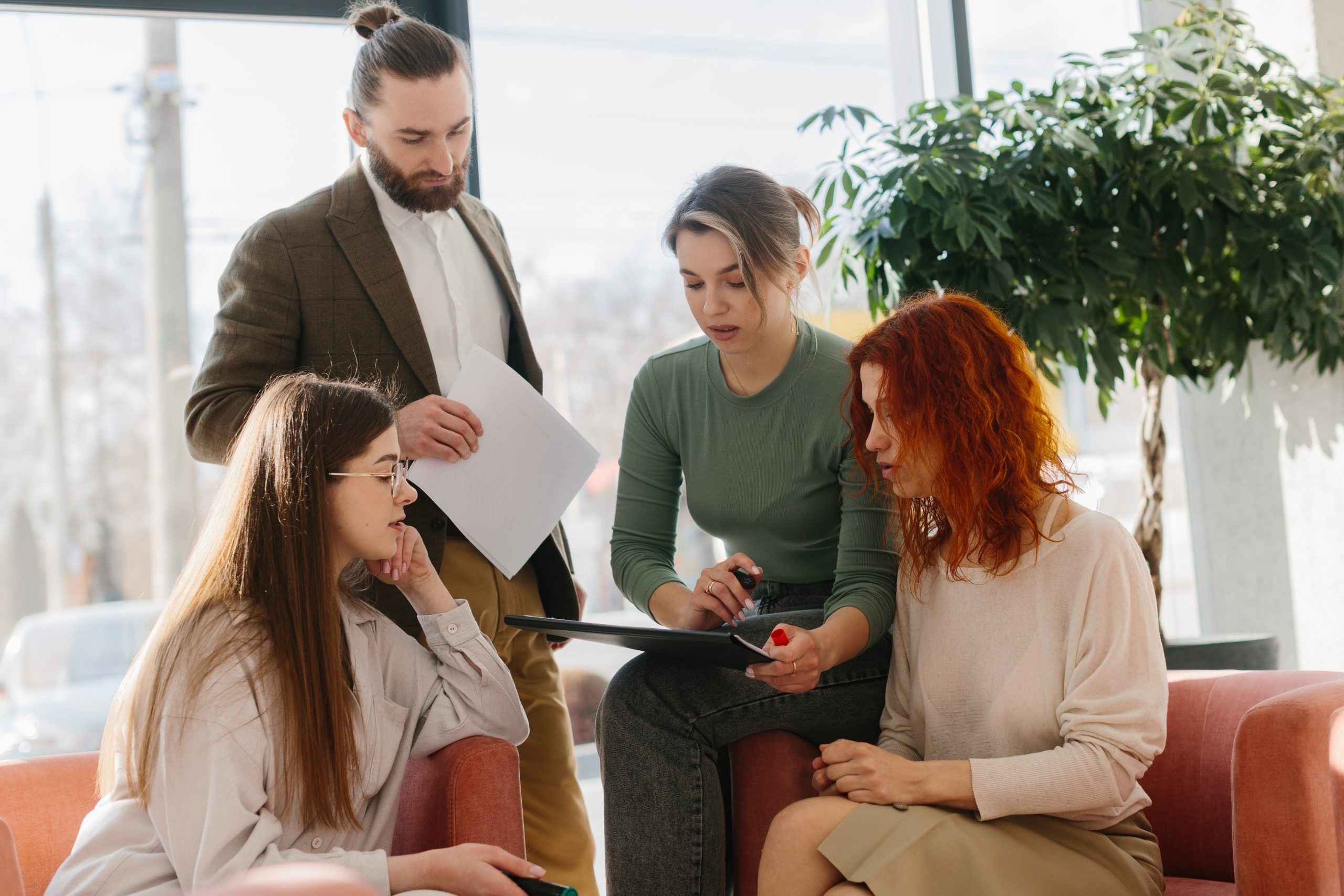 A group of women and a man during a causal workplace meeting.